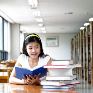 girl in library reading books