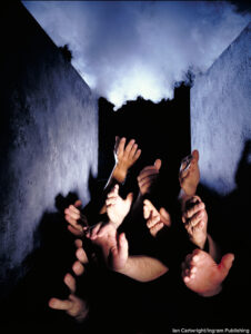 Close-up of human hands raised in a grave. © Ian Cartwright/Ingram Publishing.