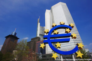 Low-angle view of the Euro sculpture in front of the Eurotower, the European Central Bank headquarters, Frankfurt, Germany.