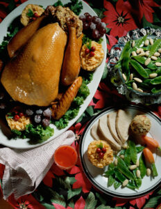 Overhead view of roasted turkey with bowl of vegetables, next to a plate with turkey, vegetables and stuffing, as if for Thanksgiving dinner. Credit: Purestock/SuperStock