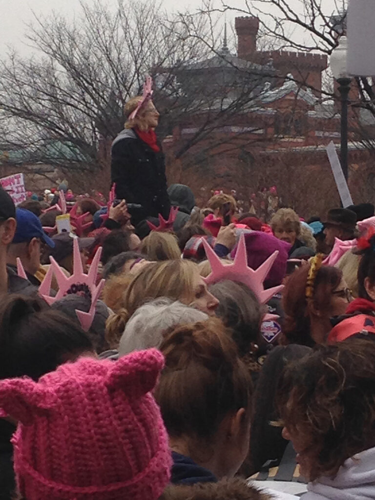 crowd with person standing above on light pole