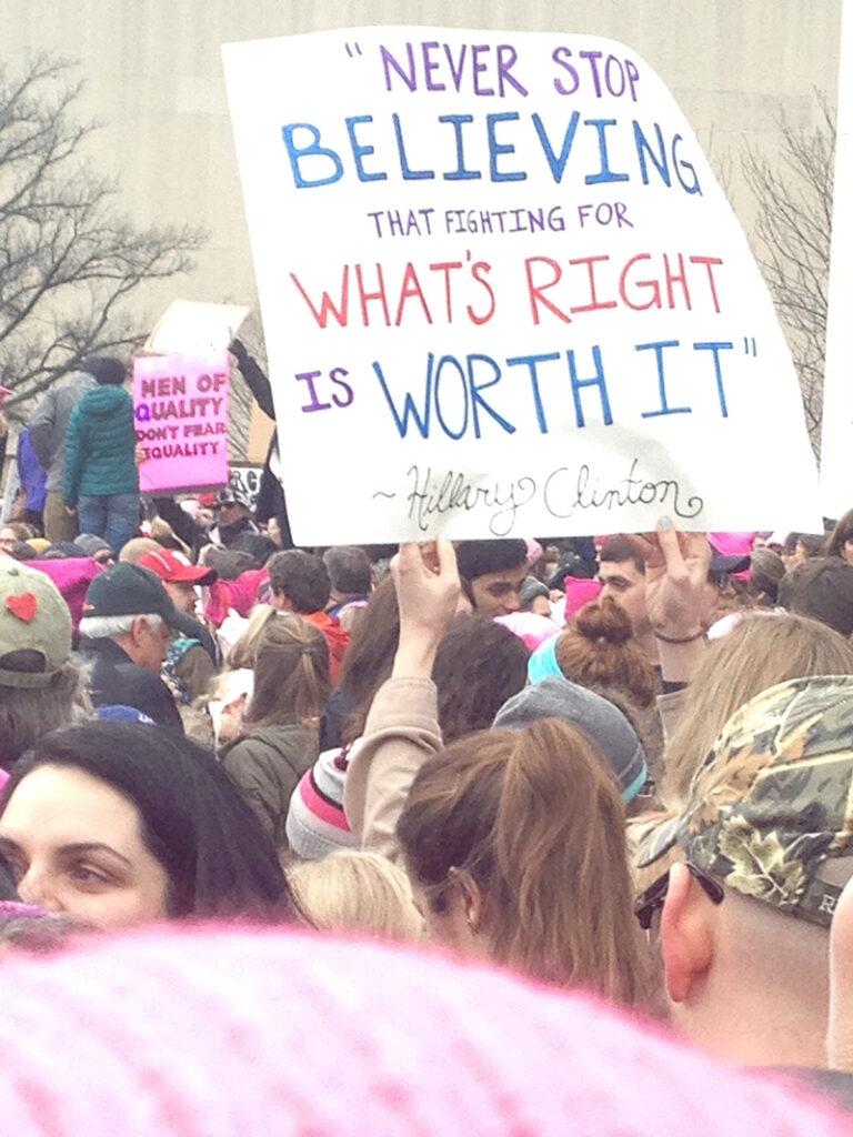 person in crowd holding up sign 