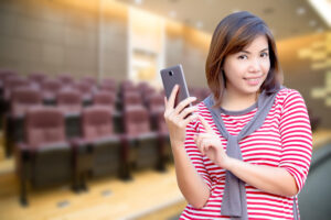 young women with smart phone feeling good and smiling see camera in meeting room