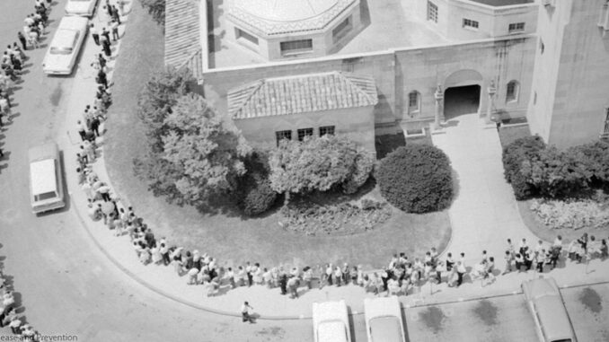 Crowd waiting for oral polio vaccine in 1962. Today CDC now recommends that we give only the injectable vaccine because of the very small chance that the oral dose can lead to a polio infection.