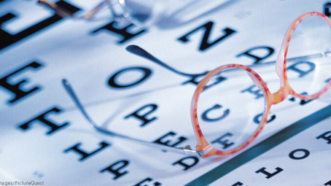 052314_03P_FS Eye exam chart with glasses on top