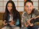Children sitting on sofa playing video games