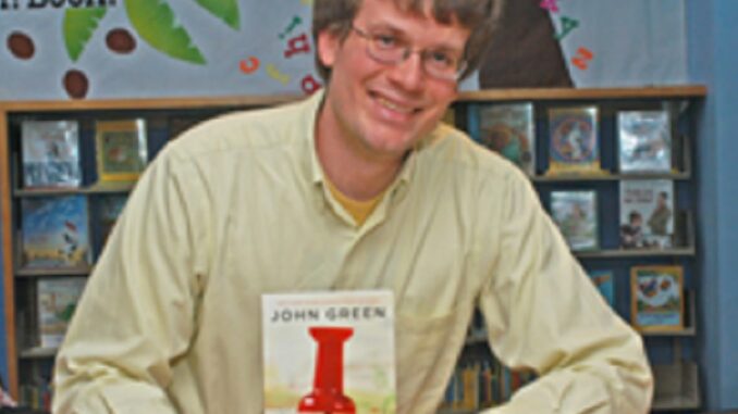 Green_Paper_Towns_Feature author John Green with his paperback novel Paper Towns