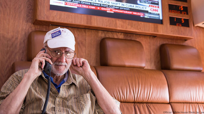 010715_03P_FS Alan Gross talks on the phone with President Barack Obama onboard a government plane during the flight from Cuba to Joint Base Andrews, Maryland, Dec. 17, 2014. Official White House Photo by Lawrence Jackson