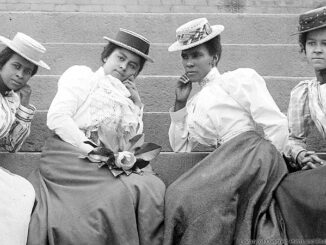 Four African American women seated on steps of building at Atlanta University, Georgia