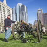 Union soldier reenactors pose with cannon.