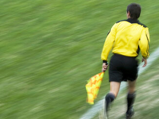Referee running on a football pitch. Photo: Glow Images