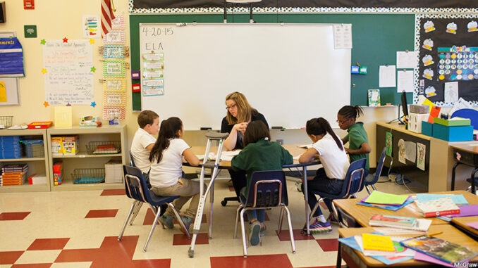 SEG029607 Students and teacher in classroom. MHE World. Photo: McGraw-Hill Education