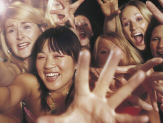 Female fans reaching towards camera. MHE World. Photo: Exactostock/Superstock