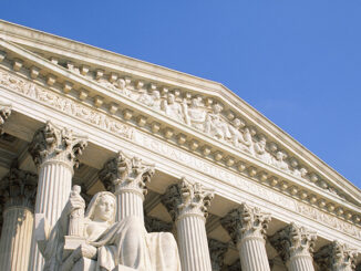 Low angle view of the Contemplation of Justice by James Earle Fraser and the west facade portico of the United States Supreme Court Building against a clear blue sky, Washington D.C., USA. Pixtal/AGE Fotostock. MHE World.