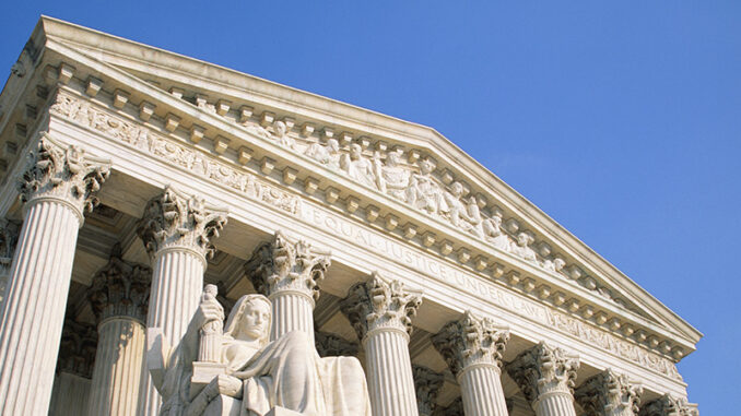 CD118047 Low angle view of the Contemplation of Justice by James Earle Fraser and the west facade portico of the United States Supreme Court Building against a clear blue sky, Washington D.C., USA. Pixtal/AGE Fotostock. MHE World.