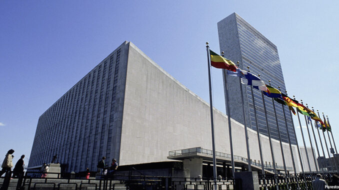 SuperStock_1574R-017968B-2 Low-angle view of the United Nations building complex, New York City, USA, with unrecognizable people milling around. Purestock/SuperStock. MHE World.