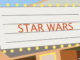 Full-length illustration of a movie theater marquee advertising the movie 'Star Wars'. McGraw-Hill Education. MHE World.