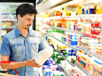 man buys milk at the supermarket. Shutterstock/Korta. MHE World