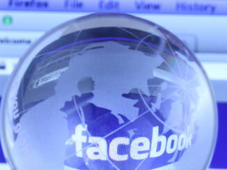 Selective focus close-up view of a small, transparent glass globe of the earth placed in front of a computer monitor displaying Facebook. The globe creates a fisheye magnification of the word 'facebook' on the screen. As of today, Facebook is the largest social media network on the web. ©dolphfyn / Alamy. MHE World