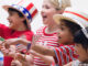 Waist-length profile view of four patriotically-dressed children (6-9) cheering during a Fourth of July parade and celebration, West New York, New Jersey. KidStock/Blend Images/Getty Images. MHE Canada;MHE USA.