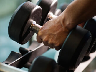 Close-up of a man's hands lifting dumbbells from a gym rack. Fuse/Getty Images. MHE Canada;MHE USA.