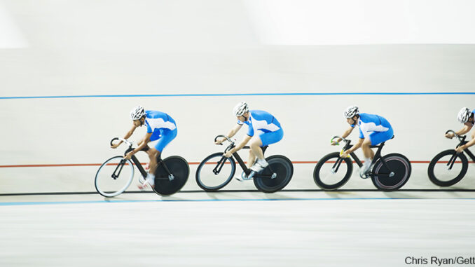 080216_01P_FS Full-length profile view of four cyclists racing around a velodrome track. Chris Ryan/Getty Images. MHE Canada;MHE USA.