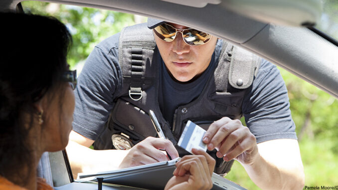 092816_02P_FS Crime: Policeman gives driver a traffic ticket. Pamela Moore/Getty Images. MHE Canada;MHE USA