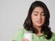 teenage female looking with slight disgust at a full glass of milk