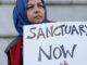 Moina Shaiq holds a sign at a rally outside of City Hall in San Francisco, Wednesday, Jan. 25, 2017. President Donald Trump moved aggressively to tighten the nation's immigration controls Wednesday, signing executive actions to jumpstart construction of his promised U.S.-Mexico border wall and cut federal grants for immigrant-protecting "sanctuary cities." Credit: Jeff Chiu/AP Images