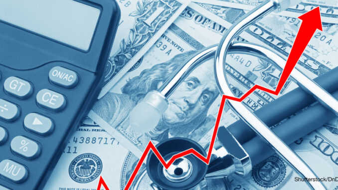 31417_02P_FS- View of a rising red graph showing the high cost of health care atop USD bank notes, a stethoscope and calculator