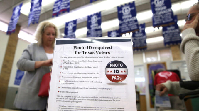 31417_03P_IS- A sign explains voter ID requirements before participating in a primary election in Arlington, Texas.