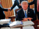 President Donald Trump sits at his desk after a meeting