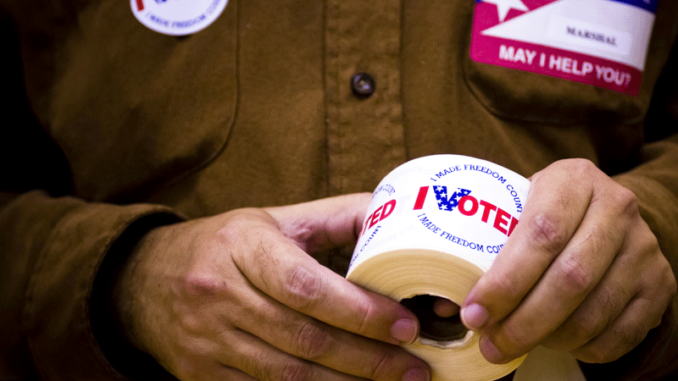 576817645 I voted stickers being passed out to people at a polling station