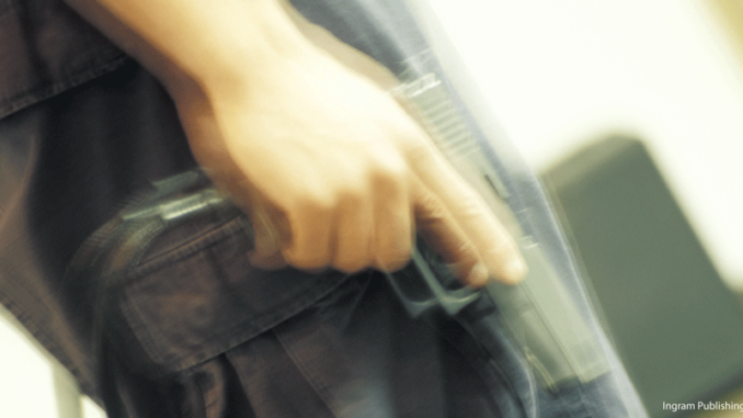 110517_01_FS Close-up, mid section, view of a man holding a handgun