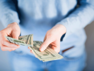 Female hands counting US Dollar bills or paying in cash.
