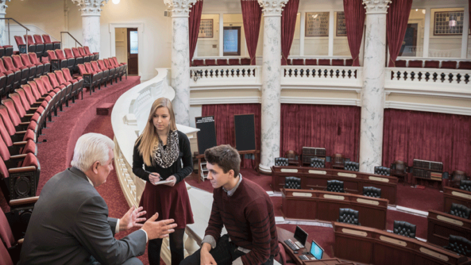 021218_01_IS High-angle three-quarter-length view of two teenagers talking to a male politician in the senate gallery of the Idaho State Capitol building, Boise, Idaho