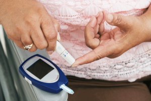 testing blood sugar with fingerprick and portable blood meter