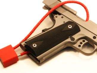 Close-up cropped view of a red cable lock on a semi-automatic pistol