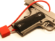 Close-up cropped view of a red cable lock on a semi-automatic pistol