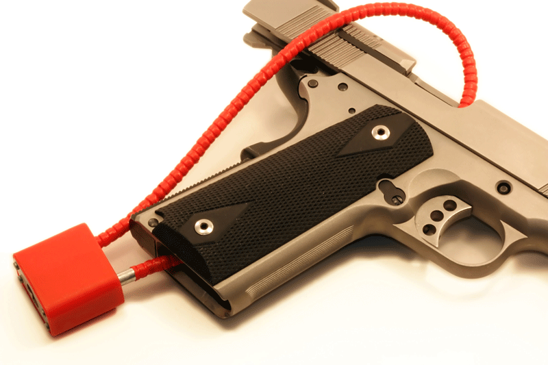 Close-up cropped view of a red cable lock on a semi-automatic pistol