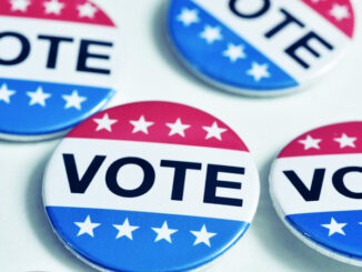 Still life of a group of vote buttons against a white background