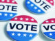 Still life of a group of vote buttons against a white background