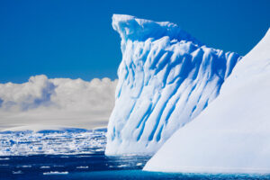 beautiful, blue iceberg floating in ocean water