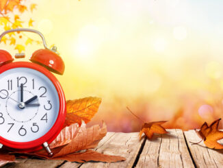 Daylight Savings Time Concept - Clock And Leaves On Wooden Table