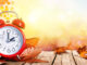 Daylight Savings Time Concept - Clock And Leaves On Wooden Table