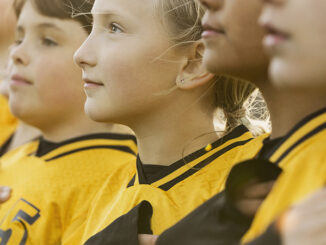 Soccer players singing national anthem