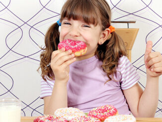 hungry little girl eat donuts
