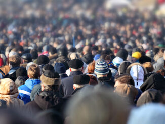 Crowd of anonymous people on street in city center, selective focus