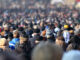 Crowd of anonymous people on street in city center, selective focus