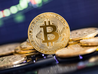 Bitcoin gold coin and defocused chart background. Virtual cryptocurrency concept